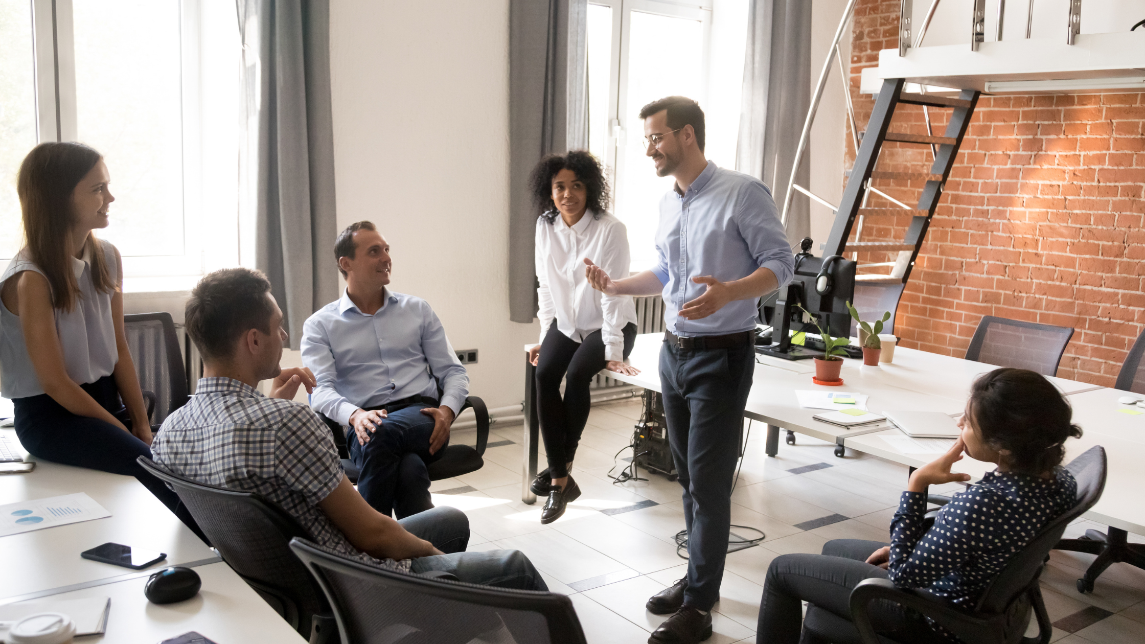 A calm, confident business leader speaking to a team — representing clear and effective leadership communication.