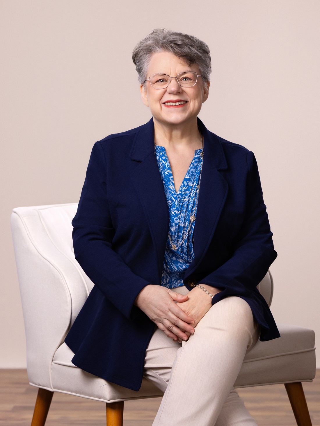 Wendy Cary, sitting in a chair with her legs crossed and hands in her lap.