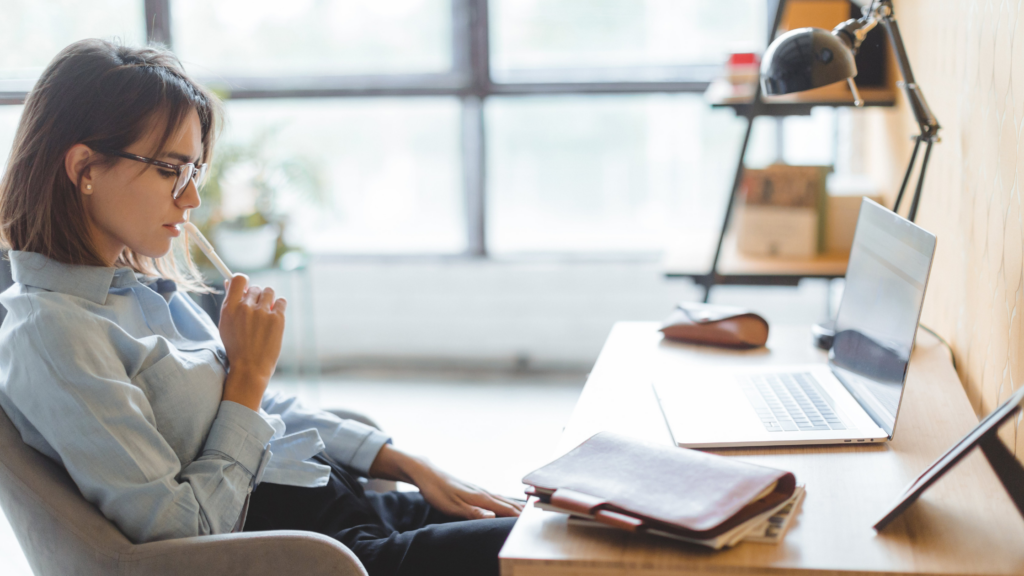 A thoughtful leader seated at a desk, pausing to reflect before making a decision under pressure.